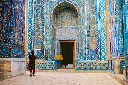 At the Shah-i-Zinda necropolis, a local lady walks between mausoleums before disappearing around a corner – Samarkand, Uzbekistan. 